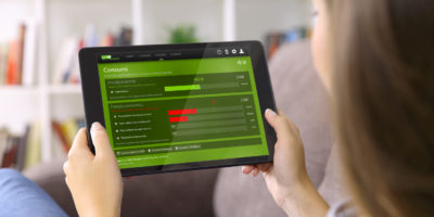 Woman watching media content showing a blank tablet screen sitting on a sofa at home